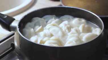 Etli börekler mutfakta kaynar suda pişirilir. Aşçı çorbayı bir yemek makinesiyle karıştırıyor, iştahı açıyor.