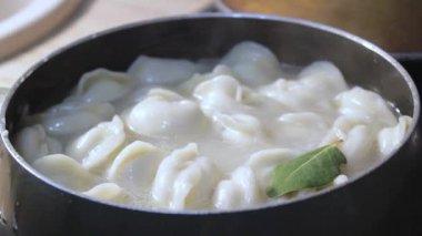 Etli börekler mutfakta kaynar suda pişirilir. Aşçı çorbayı bir yemek makinesiyle karıştırıyor, iştahı açıyor.