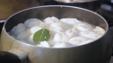 Etli börekler mutfakta kaynar suda pişirilir. Aşçı çorbayı bir yemek makinesiyle karıştırıyor, iştahı açıyor.