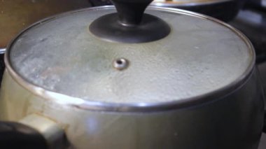 Etli börekler mutfakta kaynar suda pişirilir. Aşçı çorbayı bir yemek makinesiyle karıştırıyor, iştahı açıyor.