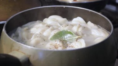 Etli börekler mutfakta kaynar suda pişirilir. Aşçı çorbayı bir yemek makinesiyle karıştırıyor, iştahı açıyor.