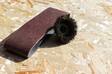 Tahtayı zımparalamak için aletler kontrplak yüzeyinde bulunur.