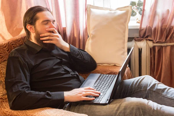 self-isolation mode in the world due to the coronavirus problem.a man with dark hair and a thick beard, works at home as a self-employed remote worker.laptop and phone, bad emotions of anger and fear