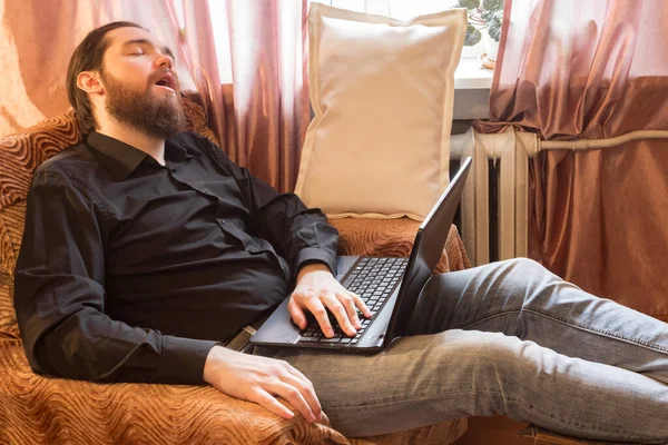 self-isolation mode in the world due to the coronavirus problem.a man with dark hair and a thick beard, works at home as a self-employed remote worker.laptop and phone, bad emotions of anger and fear