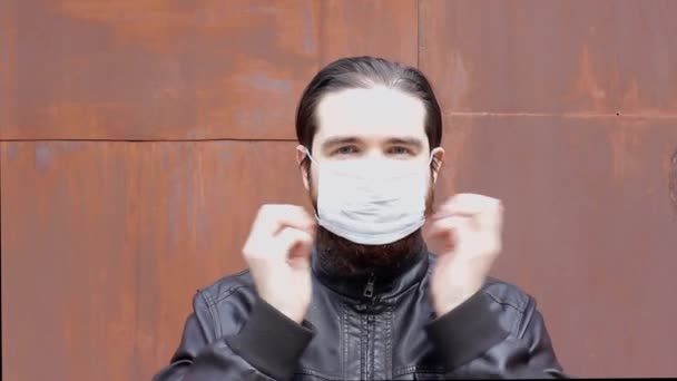 男子戴上并摘下一次性口罩 以防止头晕 说明如何正确佩戴呼吸器和口罩 如何以自我隔离和安全防范措施保护你所爱的人 — 图库视频影像