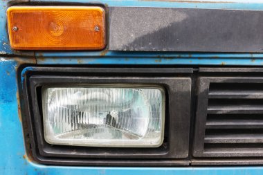 Eski bir arabanın yan ışıkları mavi renktedir. Paslanmış eski bir araba.