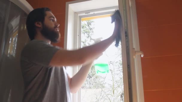 Hombre Con Una Camiseta Gris Una Barba Usa Agente Limpieza — Vídeo de stock