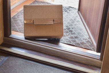 Temassız teslimat, içeriden açık kapıdan görüntü. Paket teslim edildi ve giriş kapısının dışına bırakıldı. Teslimat kutusu olan bir apartman girişi. Coronavirüs 'ün Salgın Önleme Tedbirleri