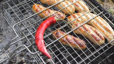 İştah açıcı sosisler ve ızgarada sıcak kırmızı biber. Kupaty tavuk, biber, soğan ve diğer baharatlardan yapılır. Evde seninkiyle kal. Tatillerde ve Coronavirüs 'te mangal yapmak için.