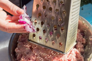 İnsan elini soğanı kıyma rendesine sürterek pişirir. Yemek pişirirken elini kullanır. Vejetaryen olmayan menü ve sağlıksız gıda konsepti