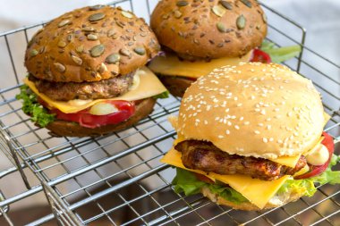 Et, peynir, domates, marul ve soğanlı ev yapımı iştah açıcı taze hamburgerler. Gerçekten yemek istediğin lezzetli fast food konsepti. Kopyalama. Uluslararası Hamburger Günü 2020
