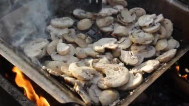 Lezzetli dilimlenmiş şampiyonlar ızgarada pişirilir. Pişirme tong ile erkek el kızartma sırasında onları çevirir. Vejetaryen mutfağı ve sağlıklı bir yaşam tarzı konsepti