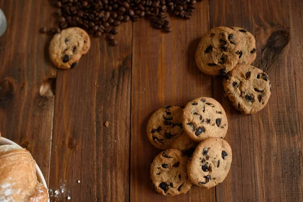 Πρωινό καφέ, κρουασάν και νόστιμα μπισκότα σε ένα ξύλινο τραπέζι. — Φωτογραφία Αρχείου