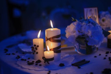 Çiçek süslemeleri ve kırmızı mumlarla süslenmiş güzel bir masa. Noel akşamı ya da düğün partisi dekorasyonu.