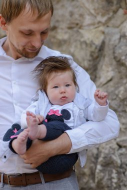 Genç babanın portresi beyaz tuğla duvarda ağlayan bir kız çocuğu tutuyor.