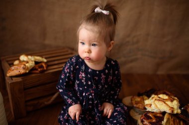 Mutfaktaki küçük kız tatlı hamur işleri yiyor..