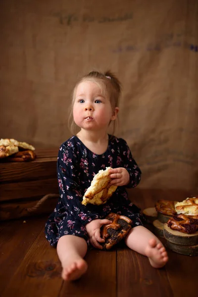 Petite fille dans la cuisine mange des pâtisseries sucrées . — Photo