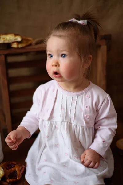 Petite fille dans la cuisine mange des pâtisseries sucrées . — Photo