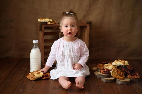 Petite fille dans la cuisine mange des pâtisseries sucrées . — Photo