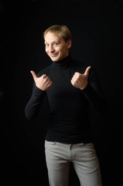 Siyah giyinmiş, siyah arkaplan giyen kararlı yakışıklı bir adamın portresi..