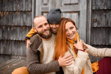 Mutlu bir aile evin girişindeki basamaklarda oturur..