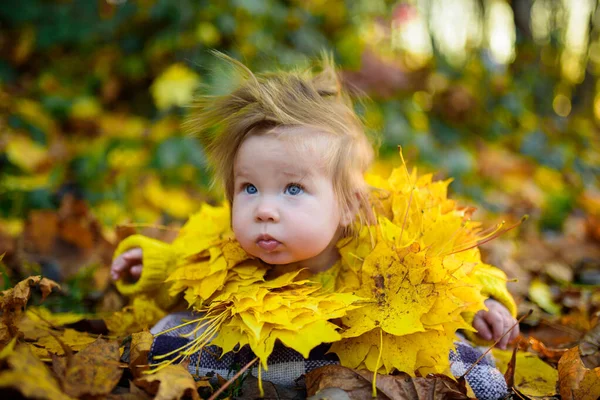 幸せな女の子が笑って屋外で遊んでいます 首には秋の葉のネックレスがあります — ストック写真