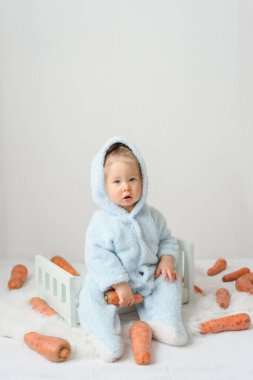 Tavşan kostümlü küçük kız işaretle kaslarını sallıyor. Sağlıklı bir yaşam tarzı ve vücudunu yaz için hazırlama kavramı..