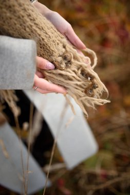 Kız elinde bir eşarp dolusu eşarp tutuyor..