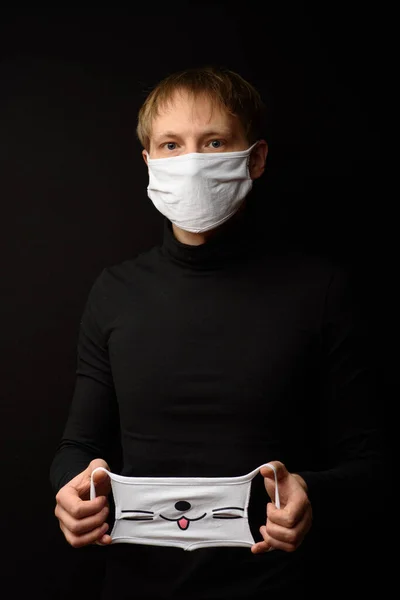 Man Black Clothes Black Background Holds His Hand Protective Mask — Stock Photo, Image