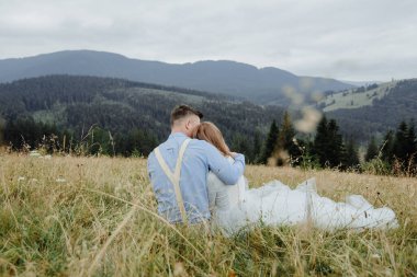 Gelin ve damadın dağlarda çekilmiş bir fotoğrafı. Boho tarzı düğün fotoğrafı..