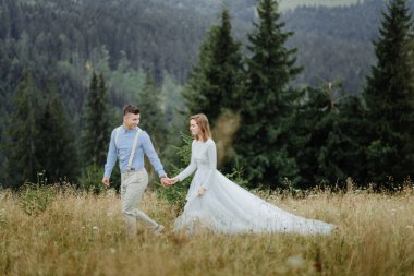 Gelin ve damadın dağlarda çekilmiş bir fotoğrafı. Boho tarzı düğün fotoğrafı..