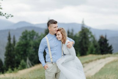 Gelin ve damadın dağlarda çekilmiş bir fotoğrafı. Boho tarzı düğün fotoğrafı..