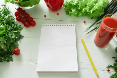 Sebzelerin arka planında kilo verme günlüğü tuttuğun defter. Bireysel bir diyet hazırlıyorum..