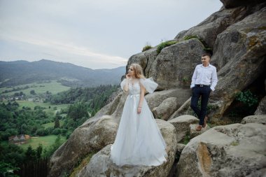 Dağlarda birbirine aşık bir çiftin fotoşopları. Kız gelinlik giymiş gelin gibi giyinmiş..
