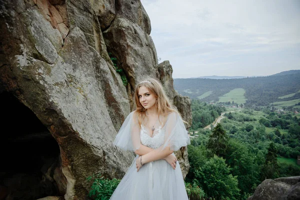 山の中で愛のカップルの写真撮影 女の子は結婚式のドレスを着た花嫁のように服を着ている — ストック写真