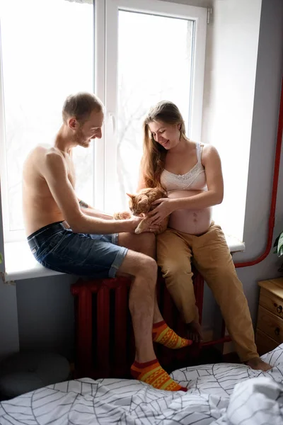 Pregnant Couple Love Sitting Windowsill Playing Cat Self Isolation House — Stock Photo, Image