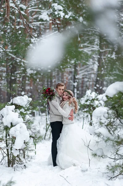 新娘和新郎带着乡村的花束出现在冬季森林的背景上 冬季婚礼 — 图库照片