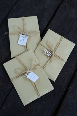 Kahverengi Kraft zarfları eski ahşap arka planda eski bir turnike ile bağlanmış ve kopyalanmış. El yapımı hediye paketi.