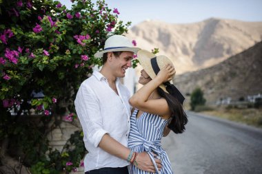 Geniş bir çalılığın arkasında yürüyen genç çift.