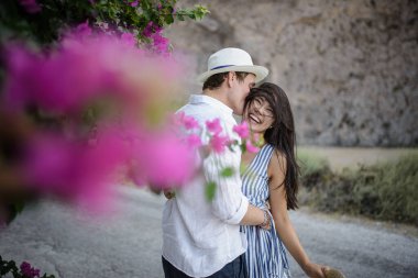 Geniş bir çalılığın arkasında yürüyen genç çift.