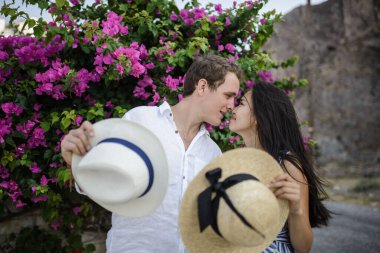 Geniş bir çalılığın arkasında yürüyen genç çift.