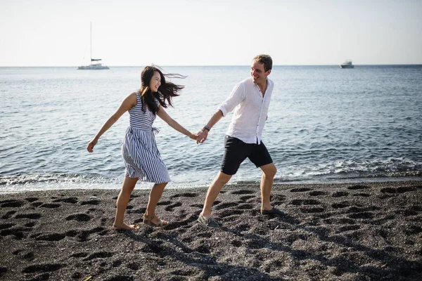 Young couple walking on the background of the sea on the island of Santorini