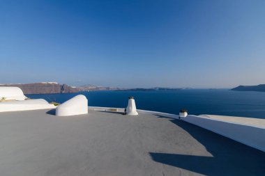 Akdeniz 'in arka planında, Santorini, Oia köyündeki otellerin çatısı..