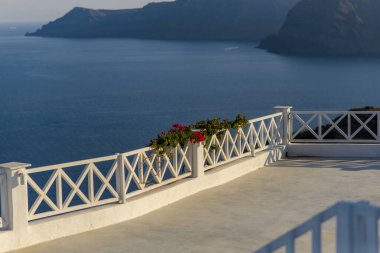 Çitlerden sarkan çiçekler denizin arka planına karşı. Oia köyünde çekildi, Santorini.