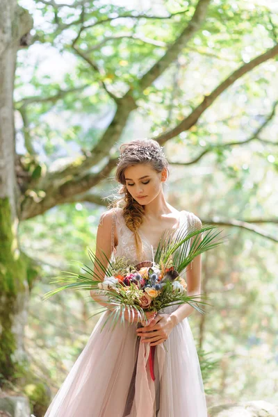 ピンクのウェディングドレスを着た幸せな花嫁 少女は結婚式の花束を手に持っている 森の中の坊式結婚式 — ストック写真