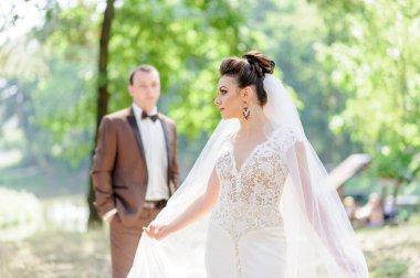 Gelin ve damat kameranın önünde poz veriyor. Geline odaklan..