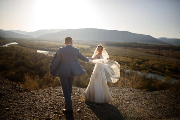 Wedding photo session of the bride and groom in the mountains. Photoshoot at sunset.