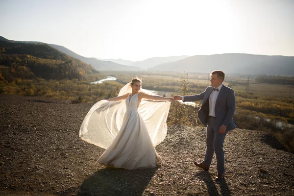 Wedding photo session of the bride and groom in the mountains. Photoshoot at sunset.