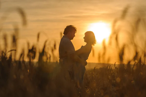 一个成年农民和他的妻子在麦田里拥抱 — 图库照片