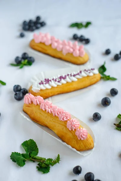 Tasty Homemade Eclairs White Tablecloth Blueberries Scattered Everywhere — Stock Photo, Image
